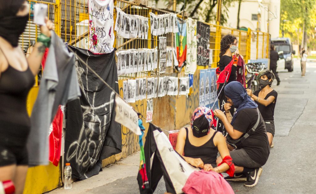 Grupo de personas con capuchas instalando una performance en buenos aires para el 18 de octubre 