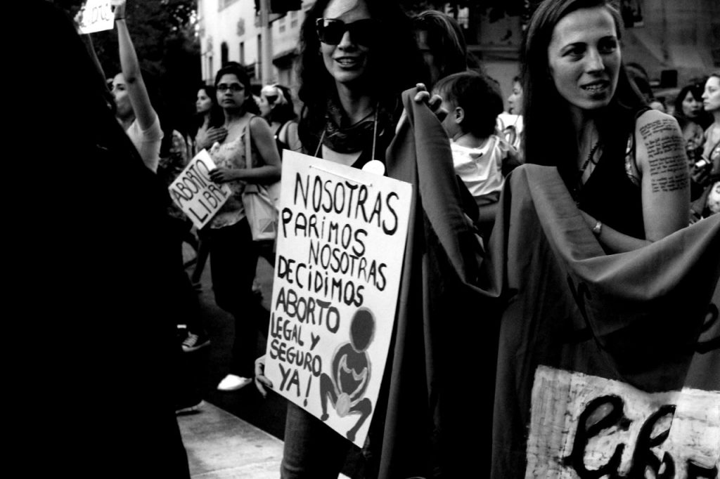 mujer con un cartel en marcha por el aborto y abortar seguramente en Chile